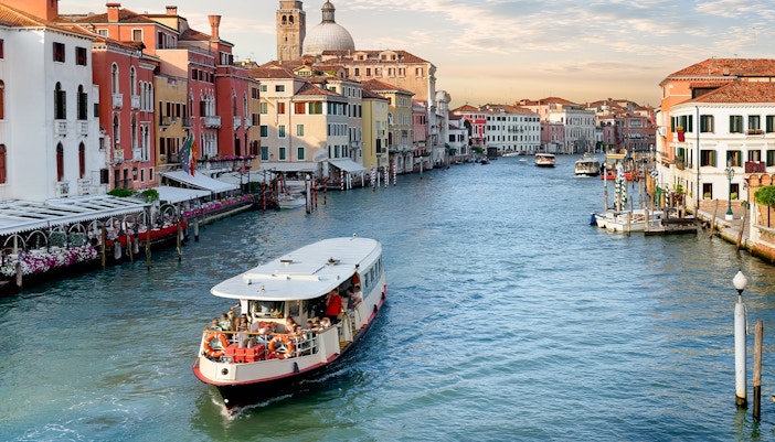 Vaporetto navigating the Grand Canal in Venice, Italy, with historic buildings lining the waterway.