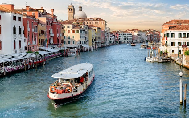 Vaporetto cruising on the Grand Canal in Venice with colorful buildings in the background.