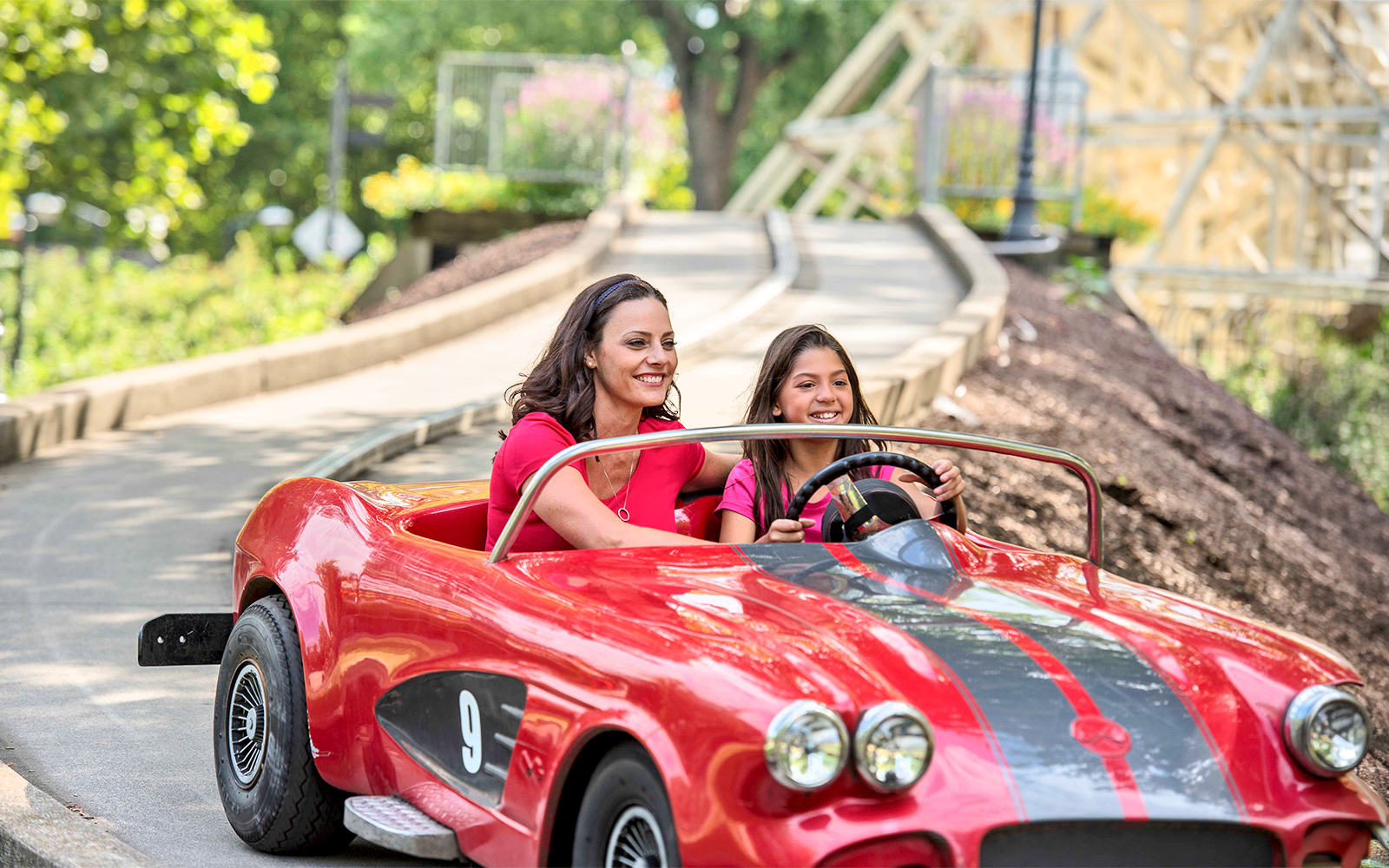 Mother and daughter driving a red car on the Road Rally ride at Dorney Park.