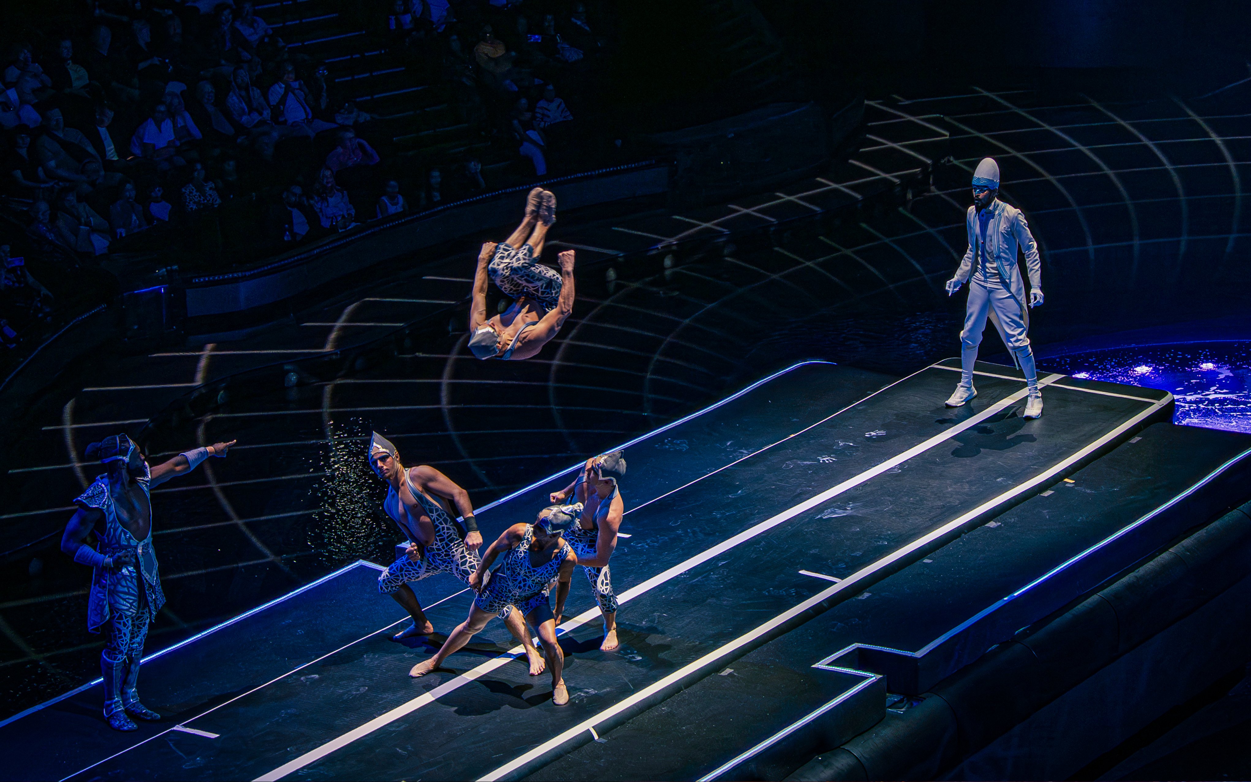 Acrobats performing mid-air flips at La Perle show in Dubai.