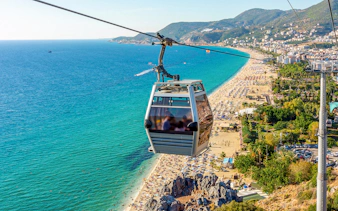 Cable car over Alanya beach with scenic coastline view.