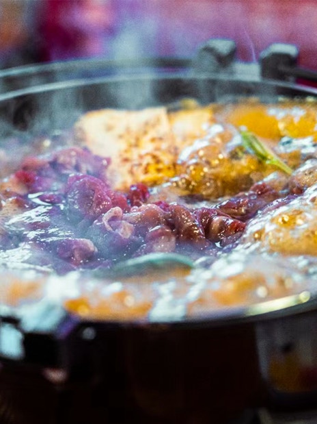 Steaming hot pot with meat and vegetables on a Yakatabune dinner cruise in Japan.