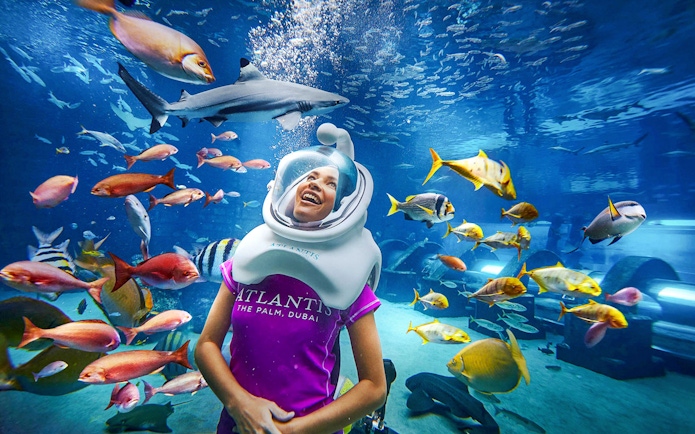 Tourist scuba diving with fish at Atlantis, The Palm, Dubai.