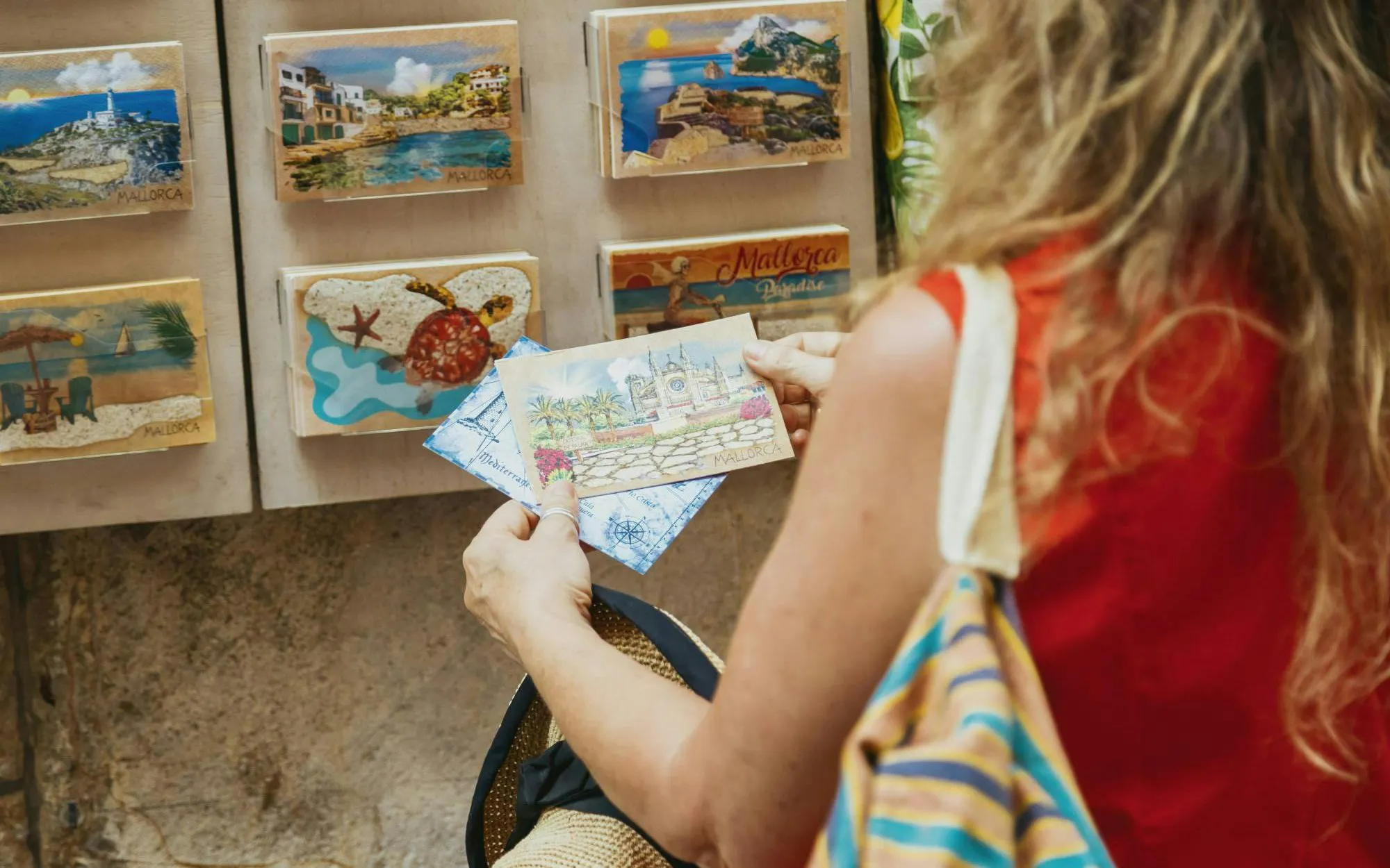 Tourist selecting postcards at a souvenir shop in Palma de Mallorca, Spain.
