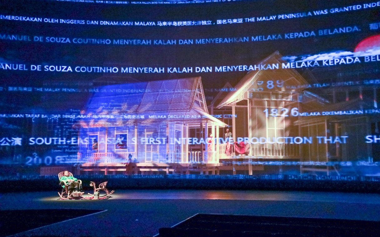 Interactive display of a traditional Kampung scene with historical text projections.