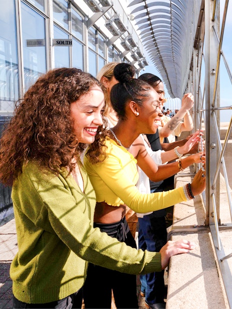 Visitors enjoying the view from the Empire State Building observation deck in New York City.