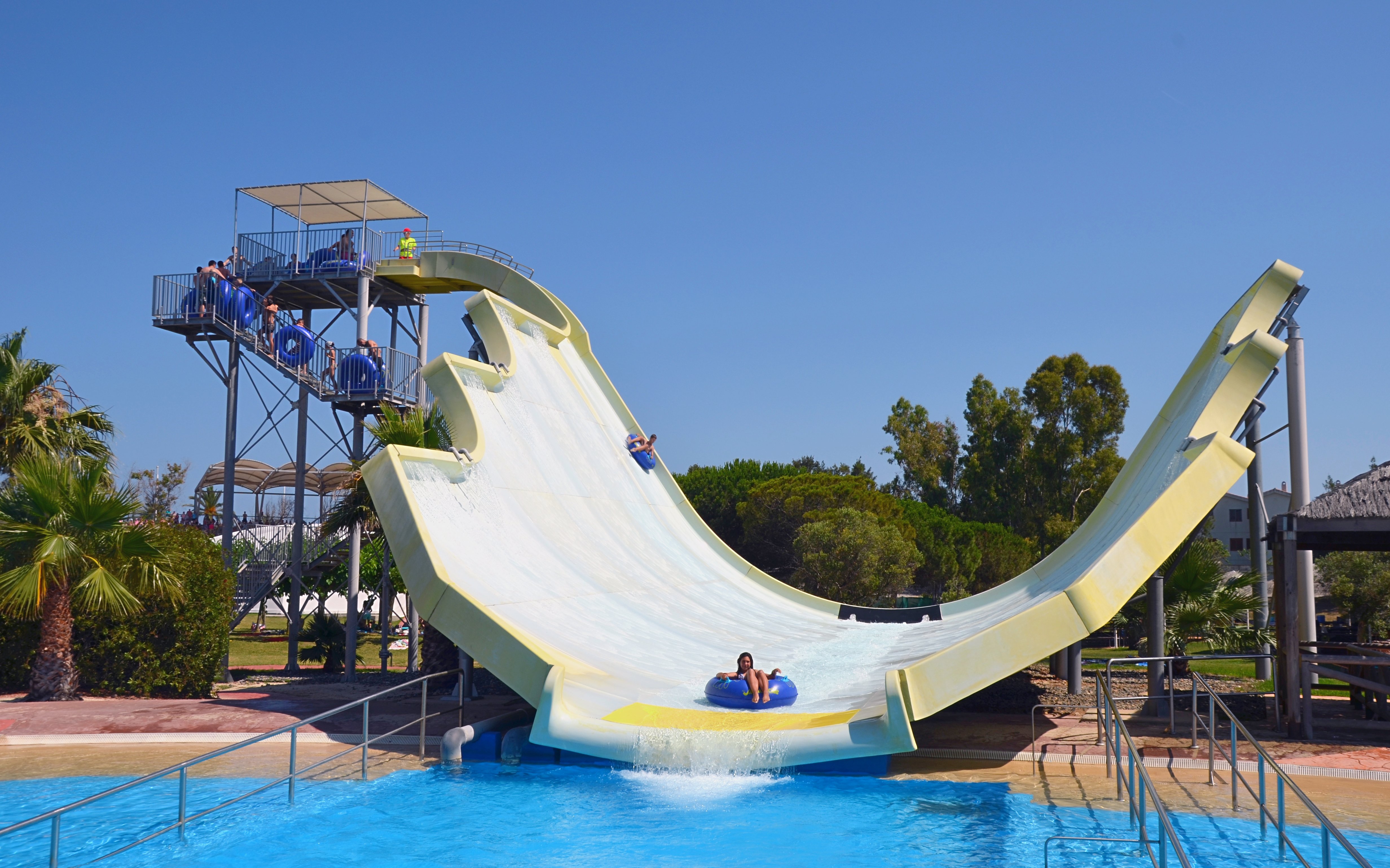 Water slide at Aquopolis Costa Daurada, Tarragona, with people enjoying the ride.