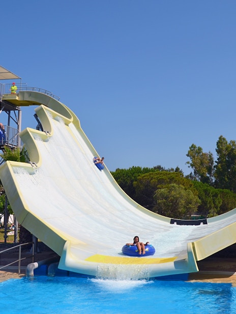 Water slide at Aquopolis Costa Daurada, Tarragona, with people enjoying the ride.