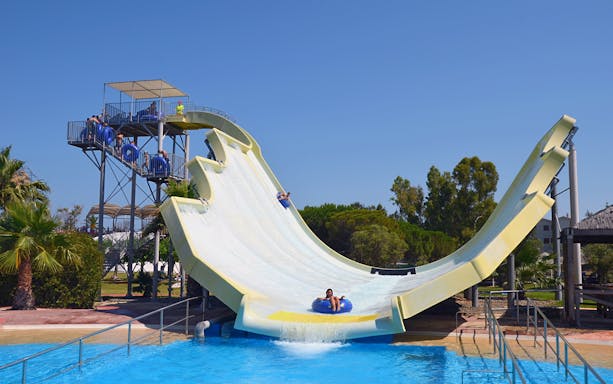 Water slide at Aquopolis Costa Daurada, Tarragona, with people enjoying the ride.