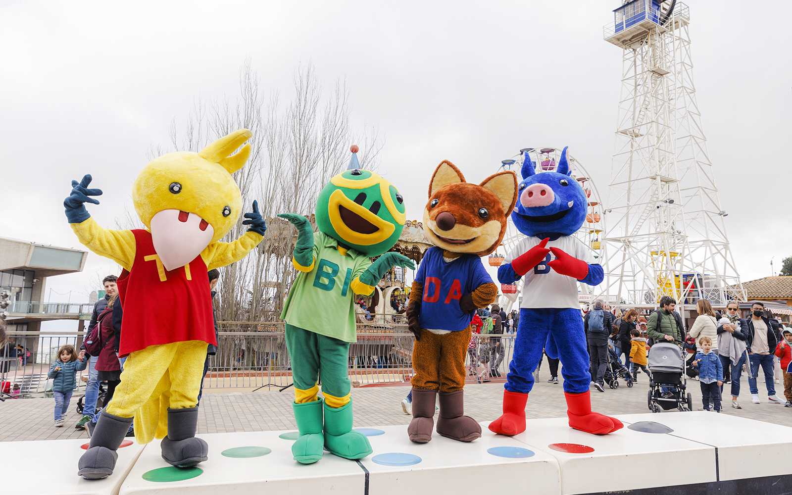 Mascots at Tibidabo Amusement Park in Barcelona with Ferris wheel in background.