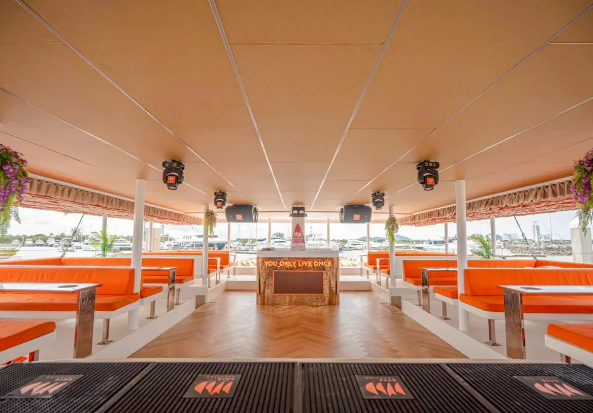 Luxury yacht interior with orange seating and bar, Pattaya cruise.