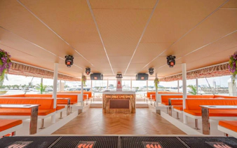 Luxury yacht interior with orange seating and bar, Pattaya cruise.