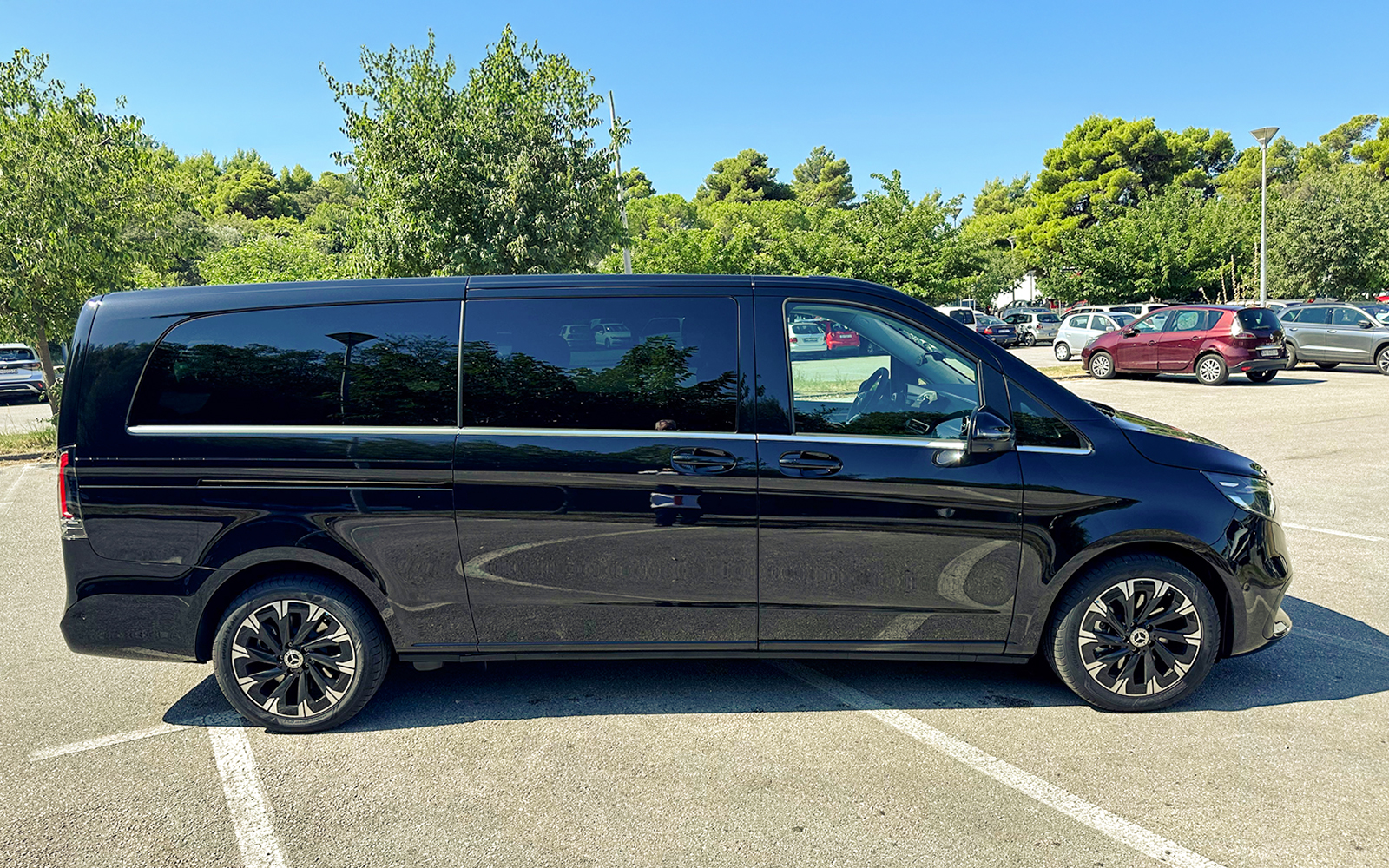 Black van for private transfer service in Croatia parking lot.