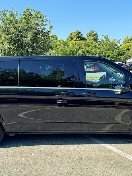 Black van for private transfer service in Croatia parking lot.