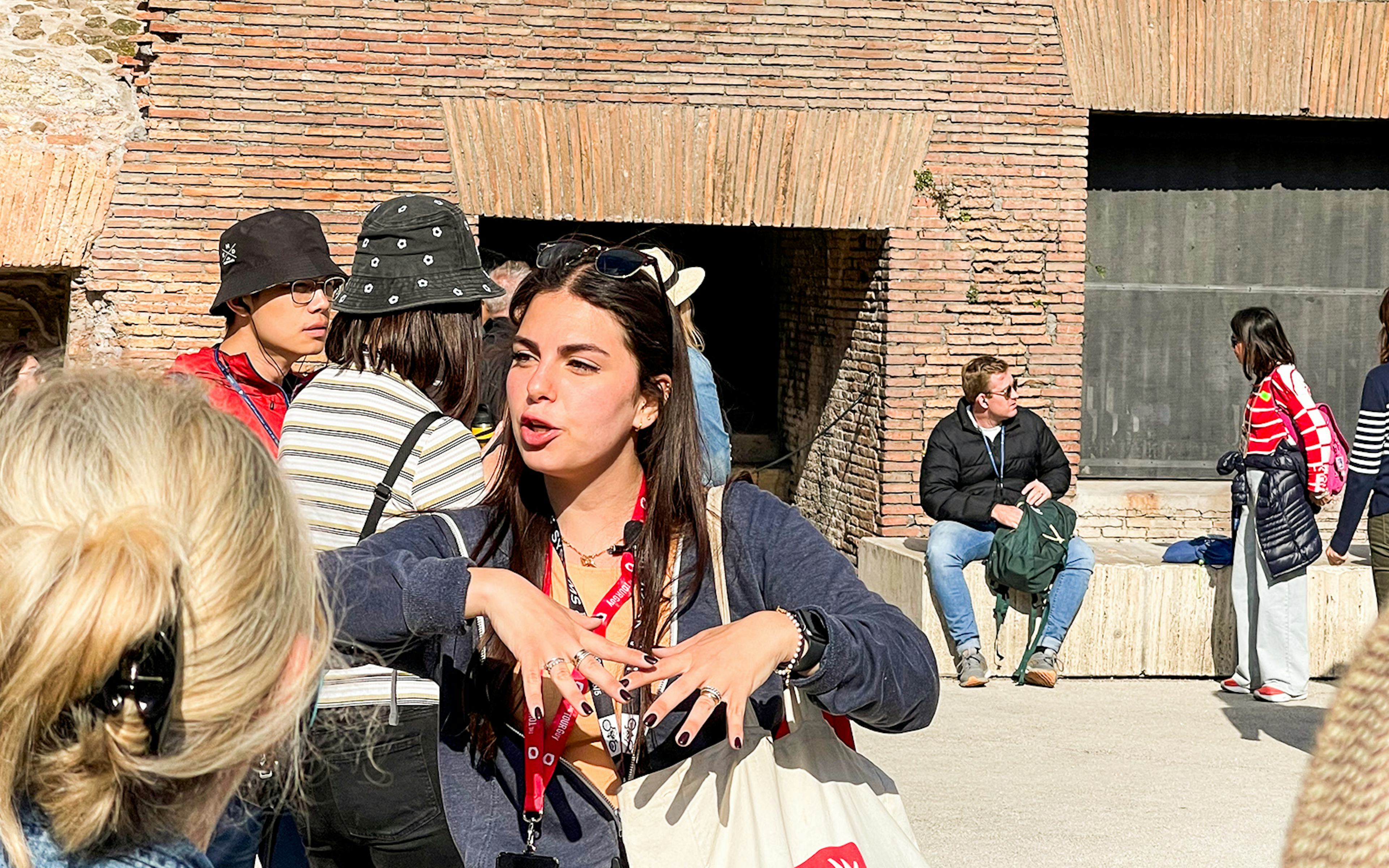 Roman Colosseum exterior with tourists exploring ancient architecture in Rome, Italy.