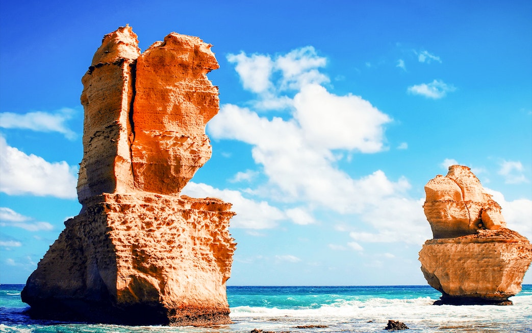 Twelve Apostles rock formations along Great Ocean Road, Australia, under a clear blue sky.