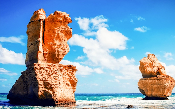 Twelve Apostles rock formations along Great Ocean Road, Australia, under a clear blue sky.