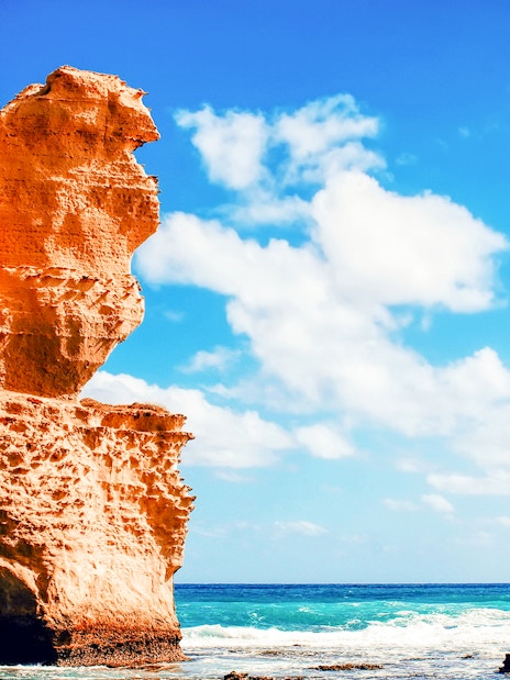 Twelve Apostles rock formations along Great Ocean Road, Australia, under a clear blue sky.