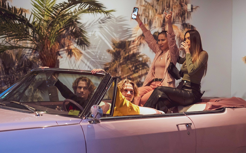 Visitors enjoying a ride in a pink convertible at the Pink Palace.