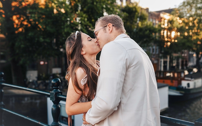 Couple kissing on Magere Brug in Amsterdam during a professional photoshoot.