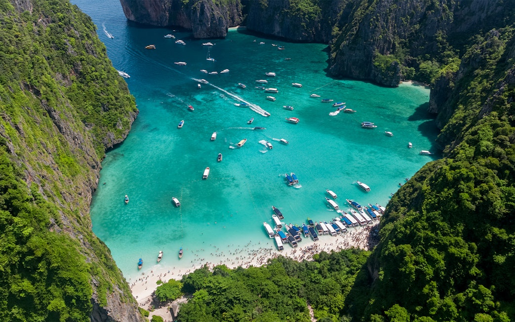 Aerial view of boats and tourists at Maya Bay, Phi Phi Island, Thailand.