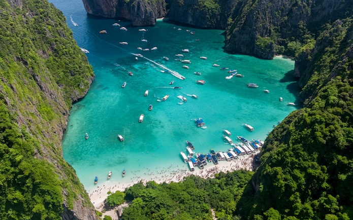 Aerial view of boats and tourists at Maya Bay, Phi Phi Island, Thailand.