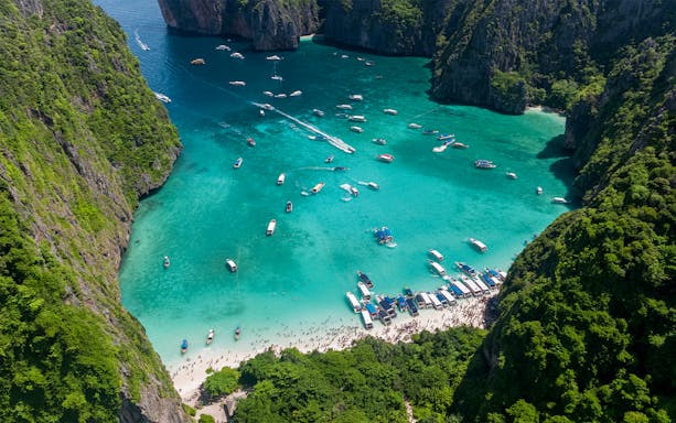 Aerial view of boats and tourists at Maya Bay, Phi Phi Island, Thailand.