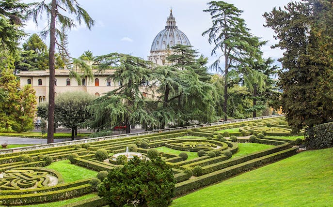 Vatican Gardens with St. Peter's Basilica dome in the background, Rome.
