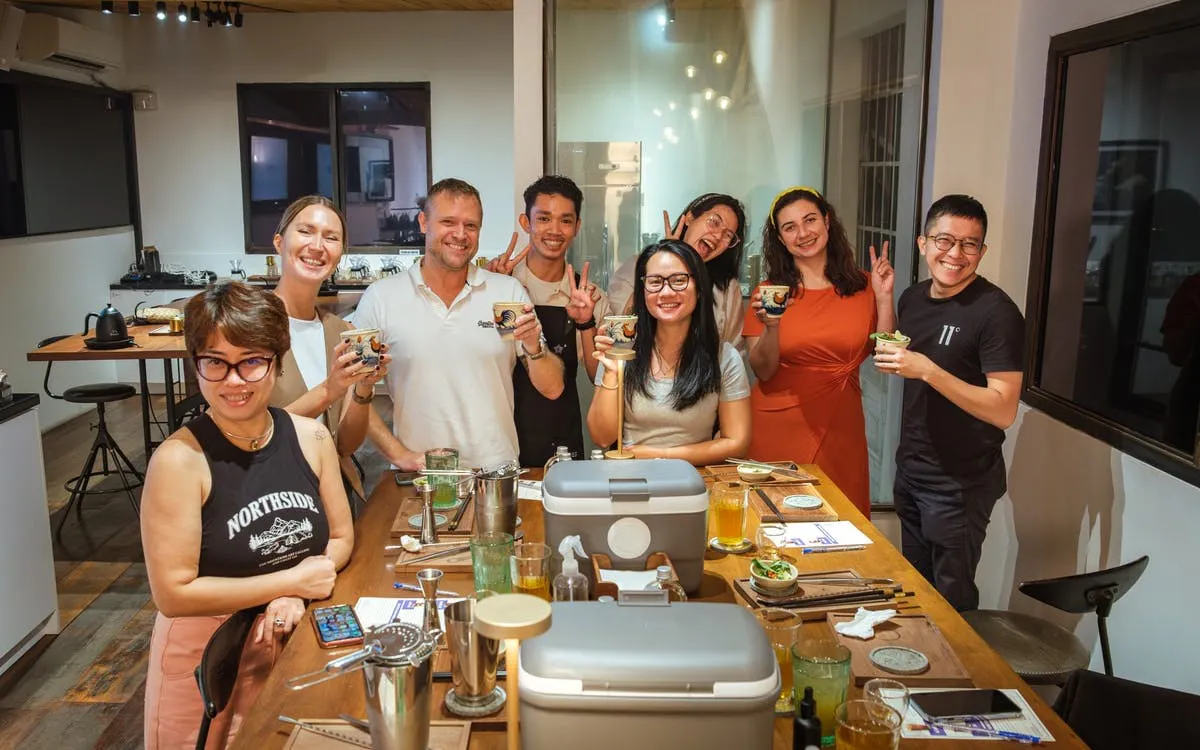 Group enjoying coffee-themed cocktails in a Vietnamese café setting.