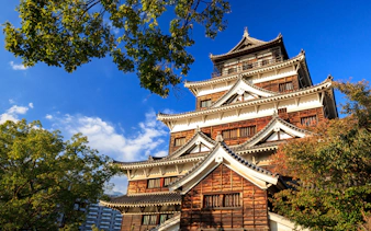 Hiroshima Castle with traditional architecture under a clear blue sky.