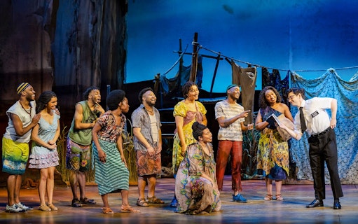 Stage performance of The Book of Mormon in Brisbane with actors in colorful costumes.