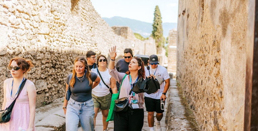 Tour group exploring ancient streets on a guided tour in Pompeii.