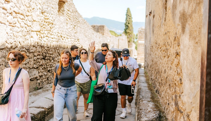 Ancient ruins of Pompeii with Mount Vesuvius in the background on a guided tour.