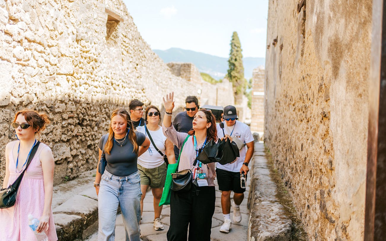 Tour group exploring ancient streets on a guided tour in Pompeii.