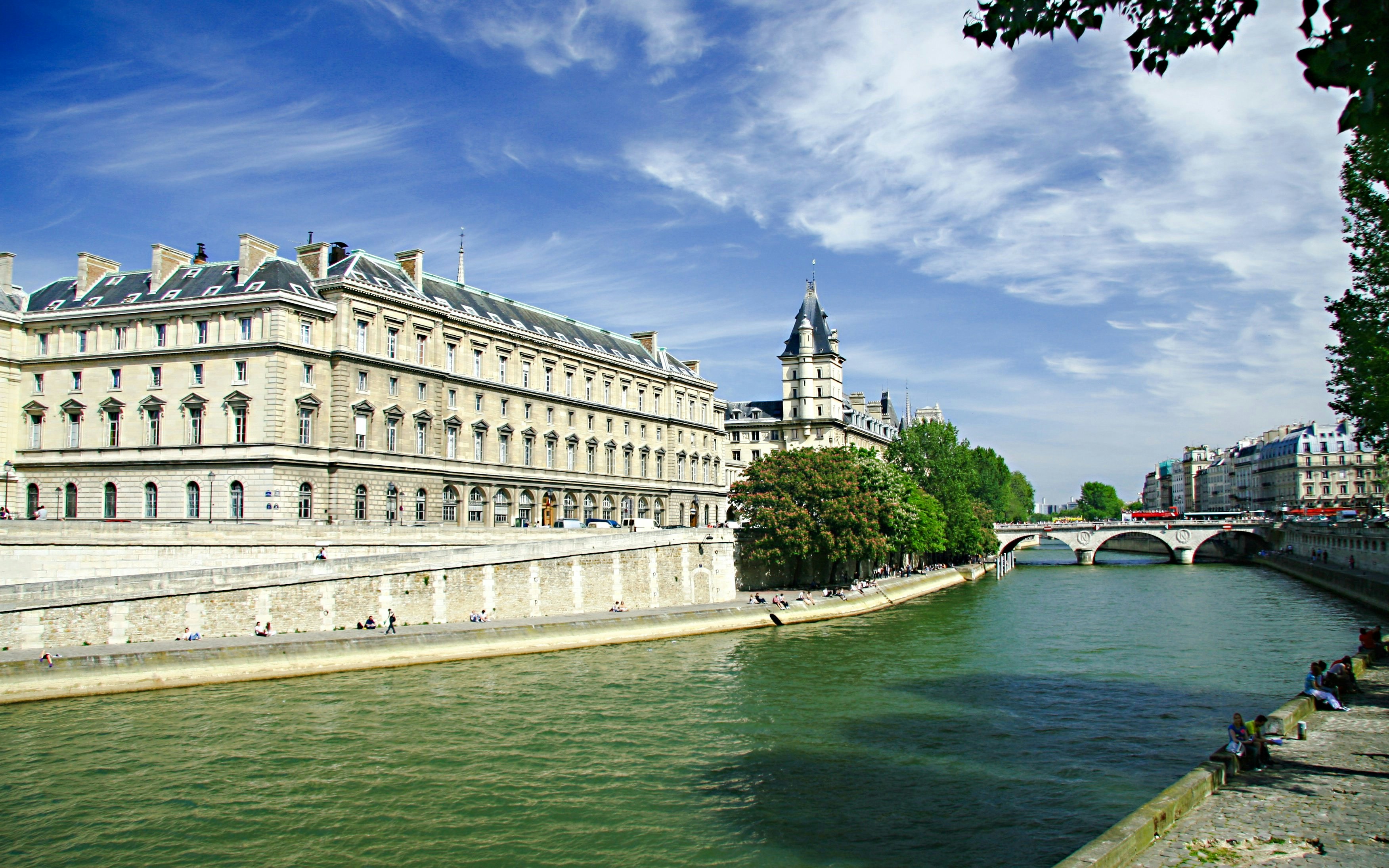 Quai de l'Archevêché along the Seine River with historic buildings and a bridge in Paris.