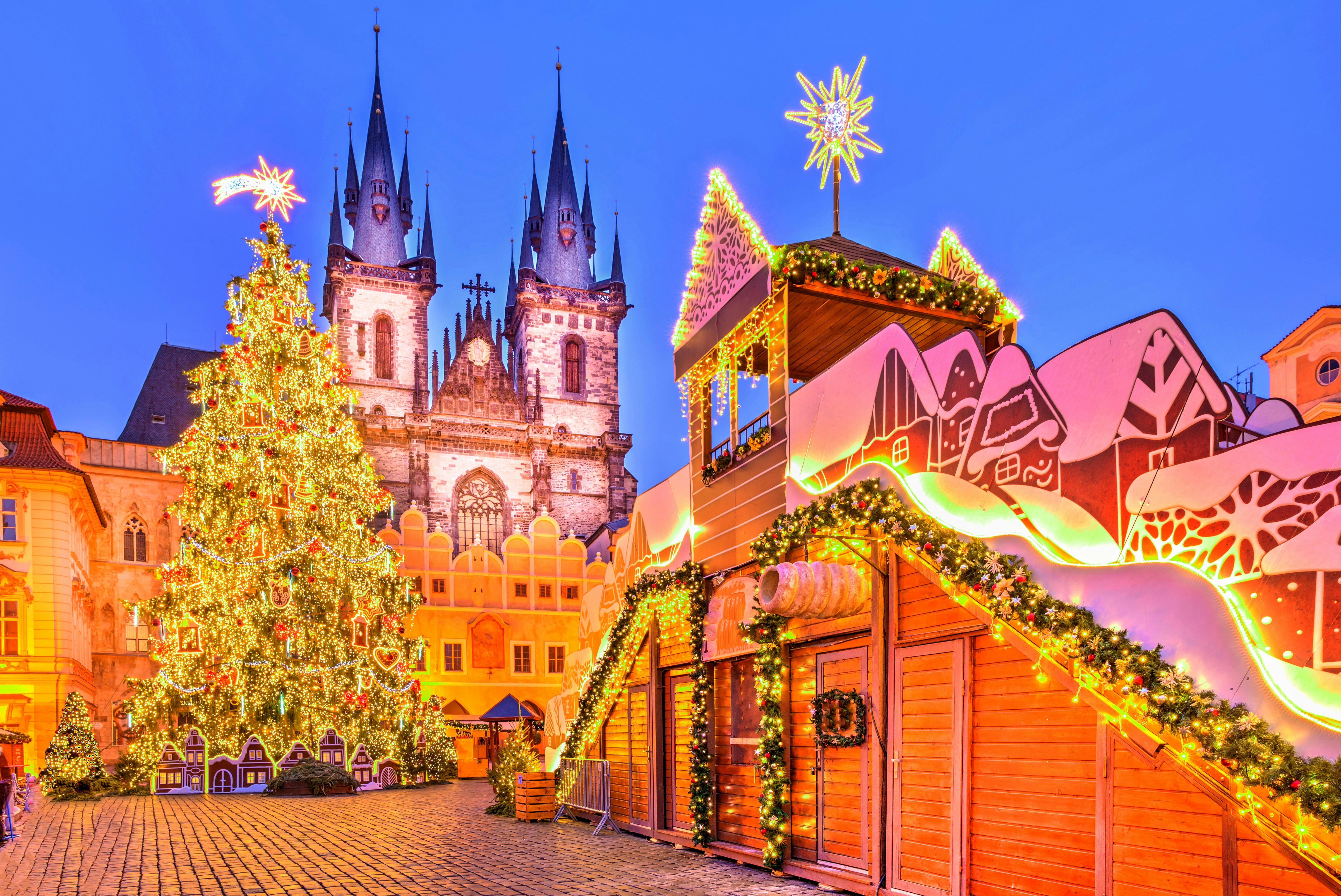 Prague Christmas market with decorated tree and Tyn Church in December.