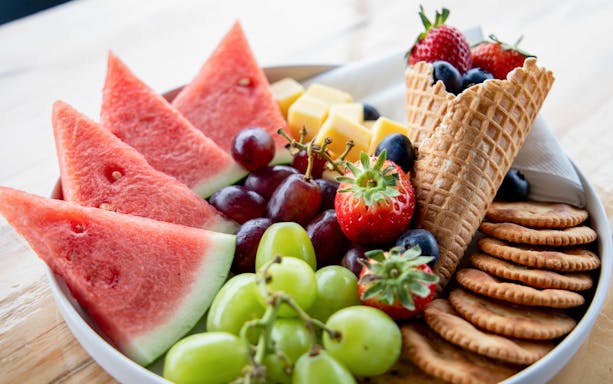 Fruit and cheese platter with watermelon, grapes, strawberries, and crackers on Phillip Island cruise.