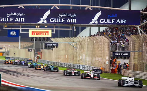 Race cars on track at Bahrain F1 Grand Prix under Gulf Air signage.