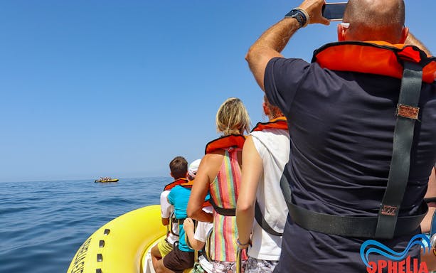 Tourists on a boat wearing life jackets, heading towards Benagil Caves for dolphin discovery.