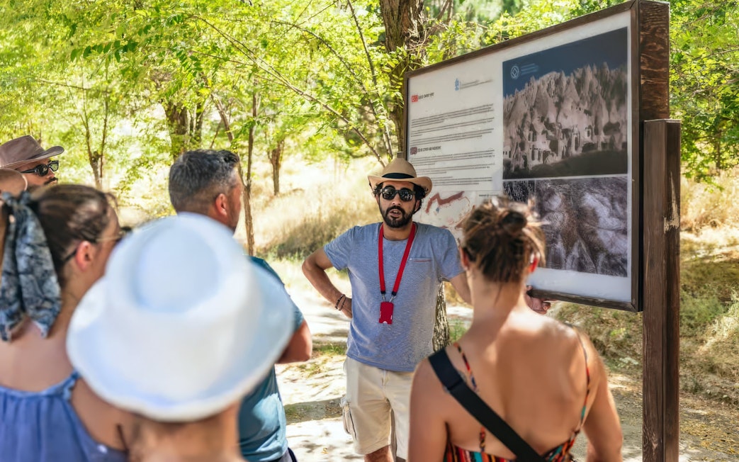 Tourists listening to a guide at Zelve Open Air Museum, Cappadocia.