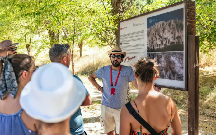 Tourists listening to a guide at Zelve Open Air Museum, Cappadocia.
