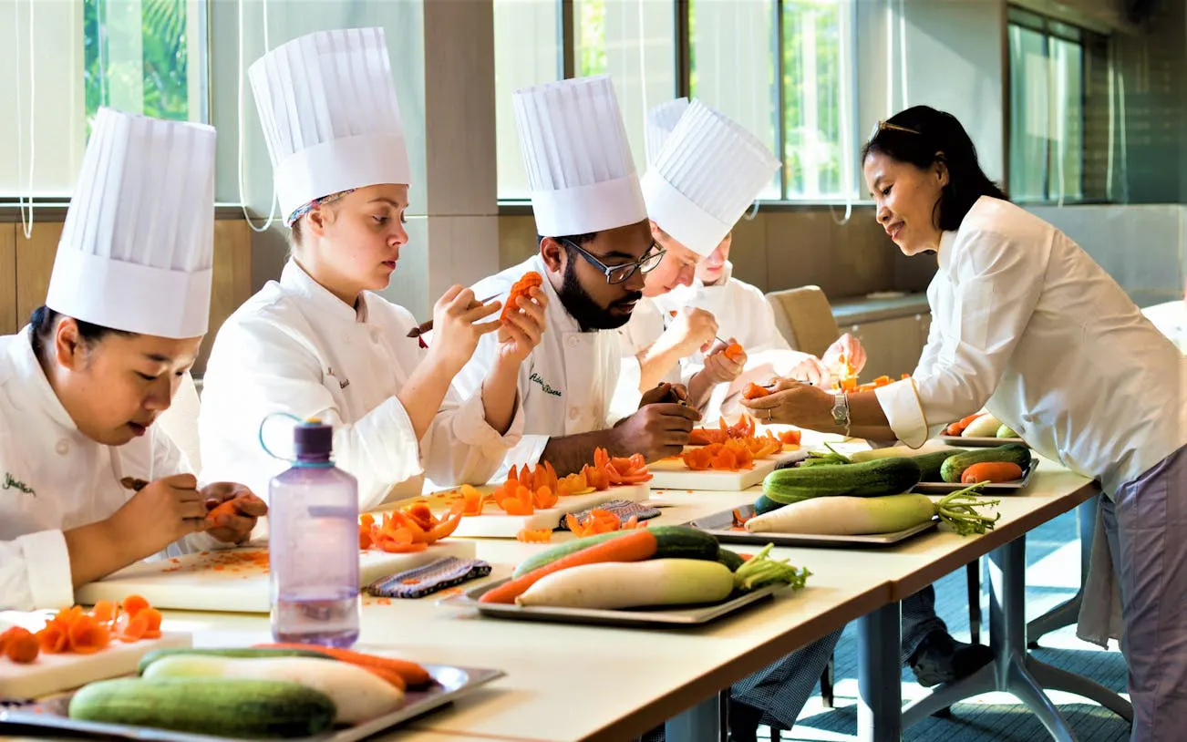 Participants carving vegetables in a Thai class with a master carver.