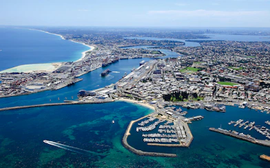 Aerial view of Fremantle Port and marina with surrounding cityscape.