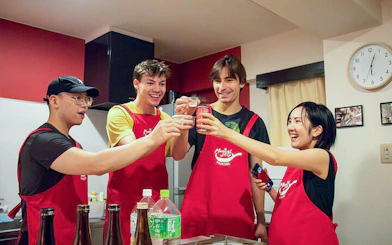 Participants toasting during Tokyo Izakaya-style cooking class with drinks.