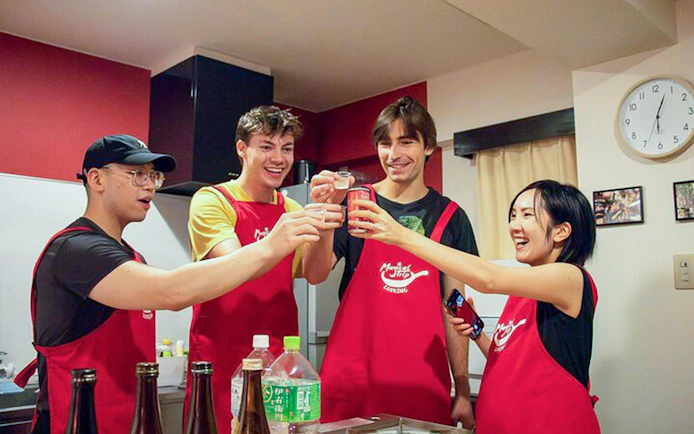 Participants toasting during Tokyo Izakaya-style cooking class with drinks.