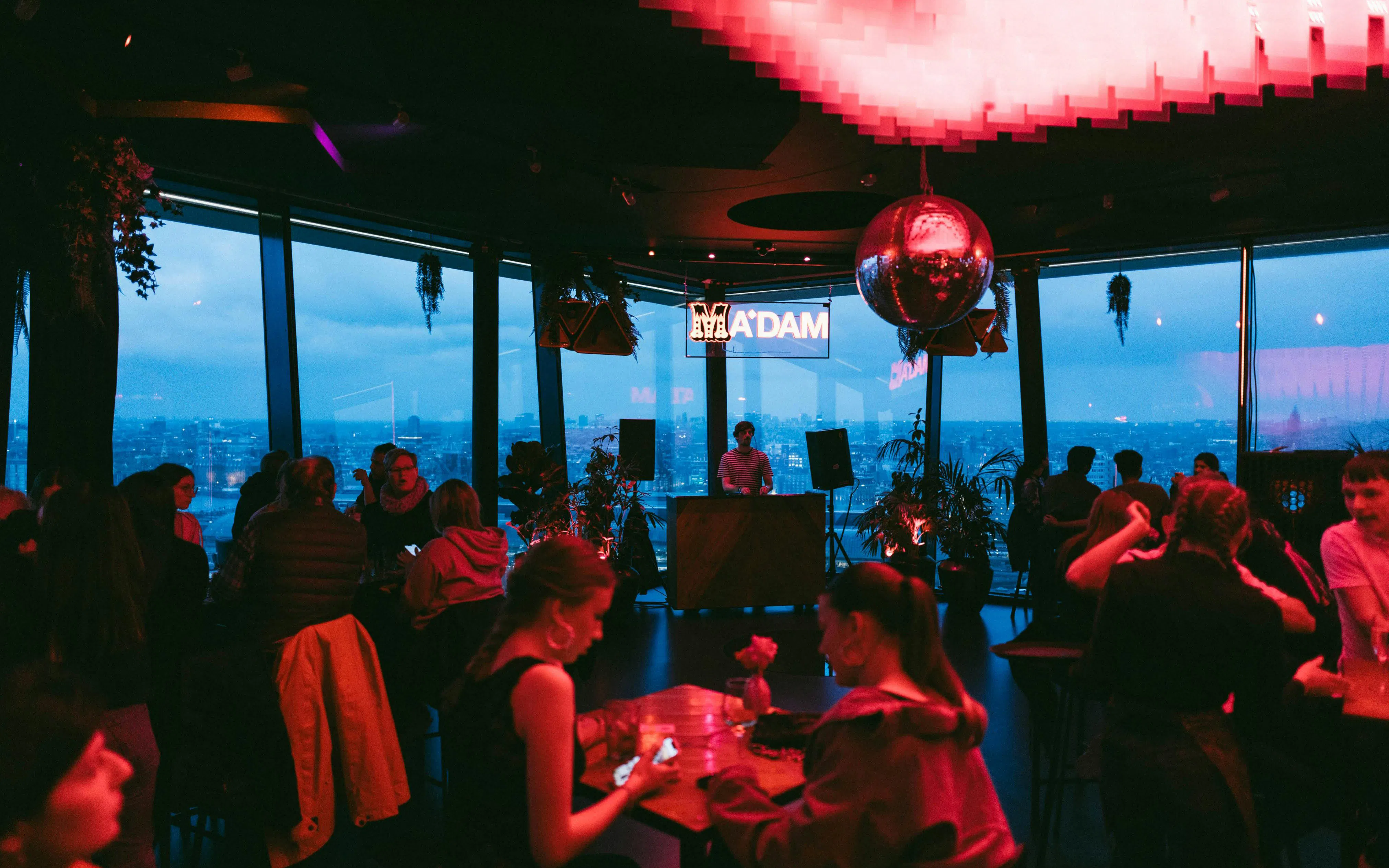 Guests enjoying the view and music at A'DAM Tower Skybar in Amsterdam.