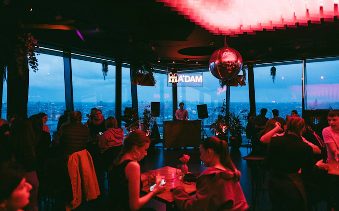 Guests enjoying the view and music at A'DAM Tower Skybar in Amsterdam.