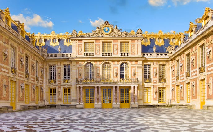 Versailles Palace courtyard with ornate architecture and golden details.