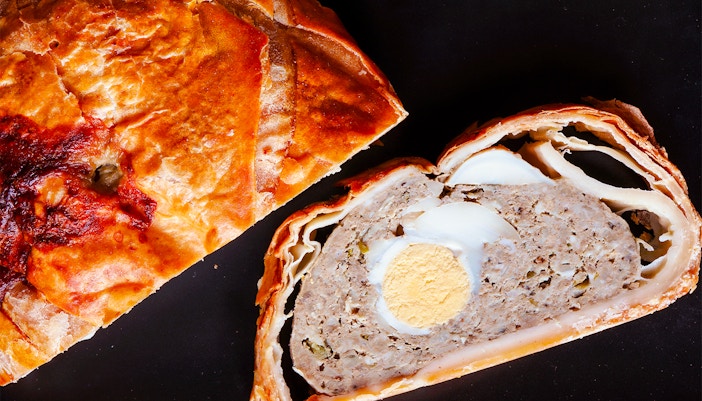 Easter meat pie and slice on slate.