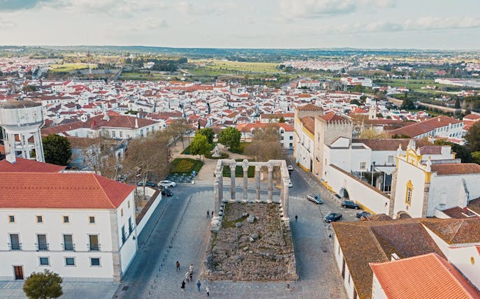 Roman Temple ruins in Évora with cityscape in the background.